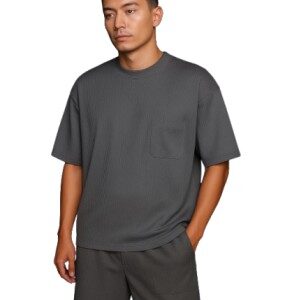Man wearing a gray dropshoulder oversized t-shirt with matching shorts, minimal streetwear fashion.