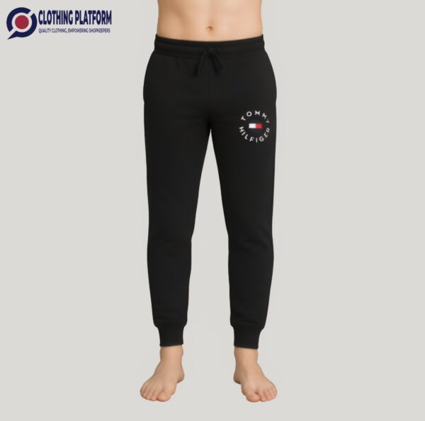 A male mannequin wearing black Tommy Hilfiger men’s trouser with drawstring waistband and logo on the left thigh.